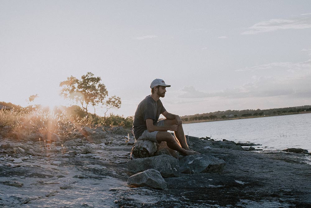 Man sitting on a beach looking at the sea